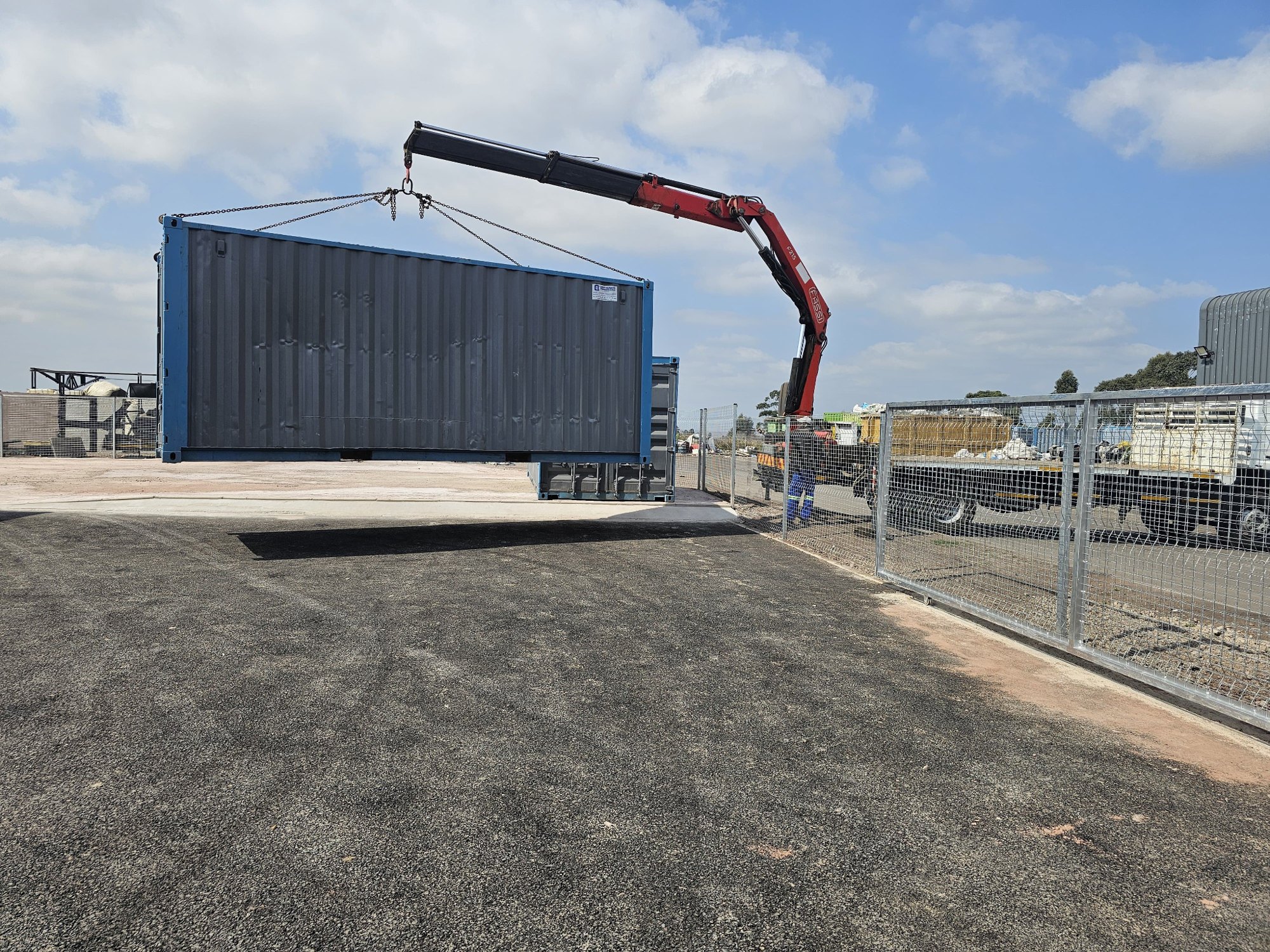 Container being positioned by crane truck