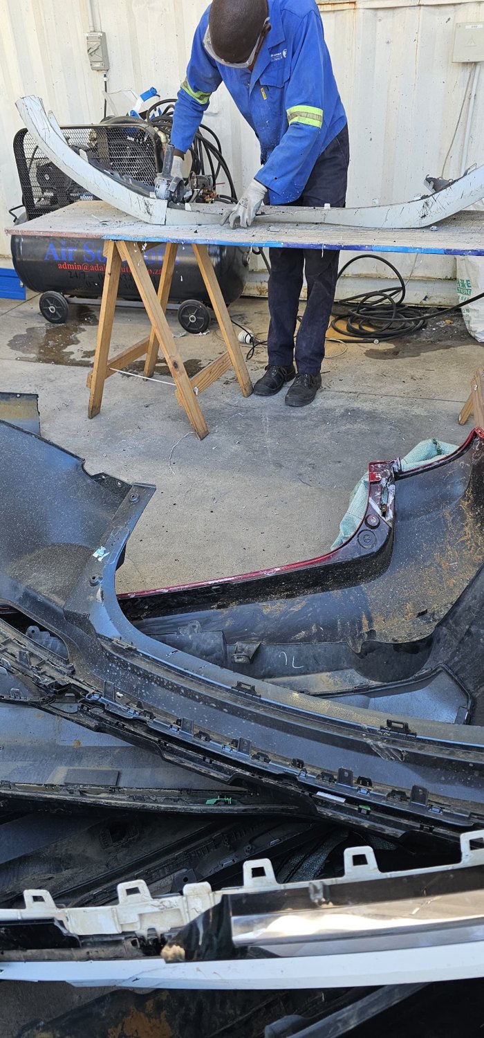 Worker dismantling automotive components